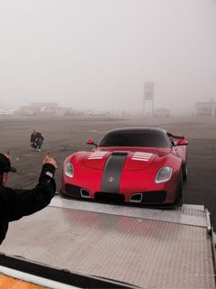Coche deportivo rojo en la niebla