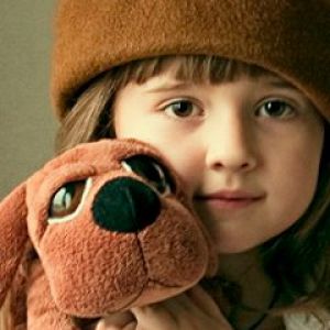 Niña con perro de peluche