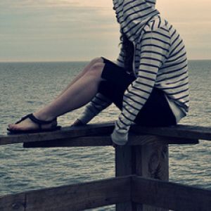 Chica contemplativa junto al mar