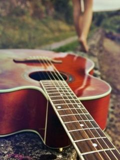 Guitarra acústica en un camino