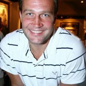 Hombre Sonriente con Camisa Rayada
