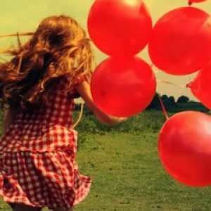 Niña con globos rojos