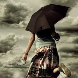 Chica con Paraguas en Cielos Dramáticos