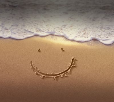 Cara sonriente en la arena