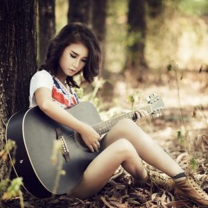 Chica Tocando la Guitarra en la Naturaleza